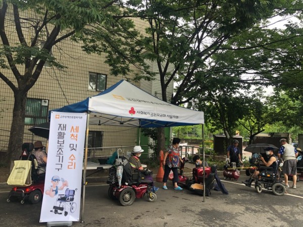 시원한 날씨 속 천막아래 재활보조기구 수리 서비스