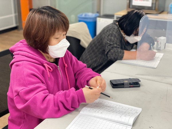 국어 공책에 열심히 쓰기 연습하는 참여자