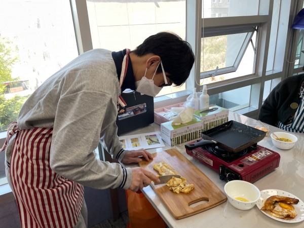 완성한 계란말이를 칼로 써는 이용자