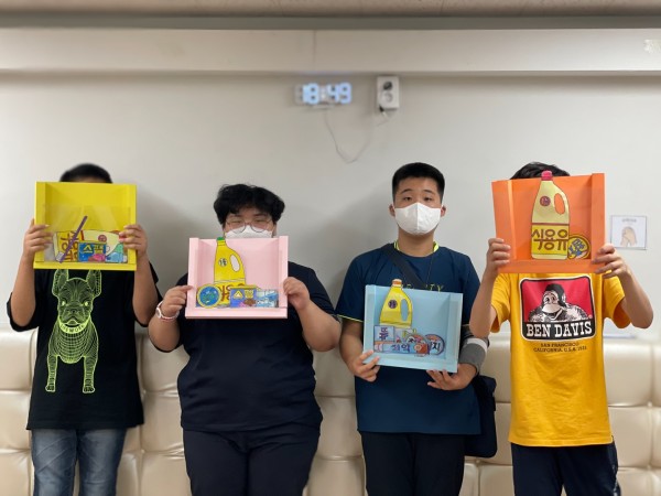 직접 만든 선물세트 들고 단체로 사진찍는 네 명의 이용자