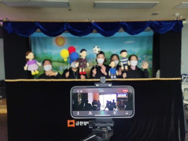 단원들을 찍고있는 스마트폰과 화면 속 아이들의 모습
