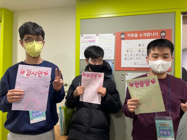 1조 조원 3명이 롤링페이퍼를 들고 카메라를 보며 뽐내는 모습