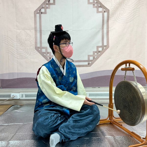 전통 테마 사진관에서 한복을 입고 징을 치는 모습을 찍은 사진