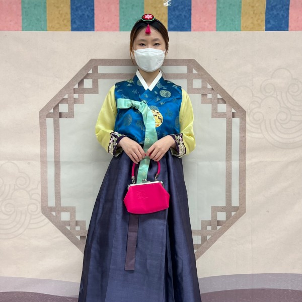 전통의상을 입고 전통 배경 앞에서 사진찍는 모습
