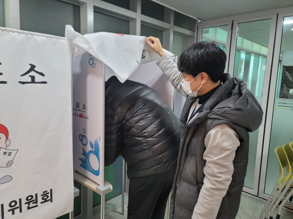 투표소 안에서 도장을 찍는 이용자 모습