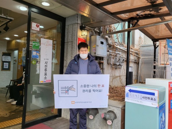 사전투표소 입구에서 투표 인증샷 찍는 모습