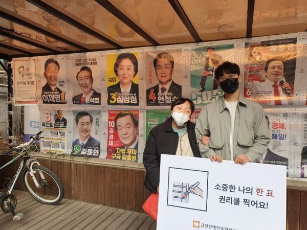 후보포스터 앞에서 인증샷 찍는 모습