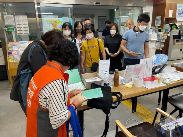 독산1동 주민센터에 비치된 AAC 의사소통책자 구경하는 종사자들