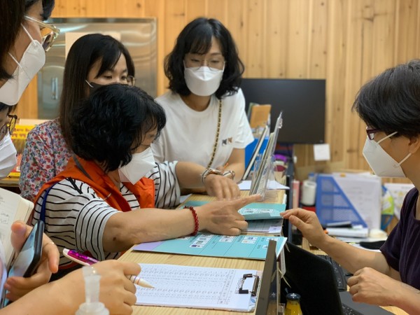 해오름도서관에서 도서 문의하는 AAC 모니터링단원과 종사자들