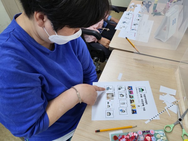 AAC로 사진관 방문하기 전 사전교육받는 이용자