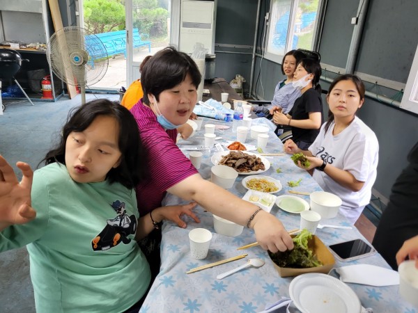 삼겹살 쌈을 싸며 바비큐 파티를 하는 모습