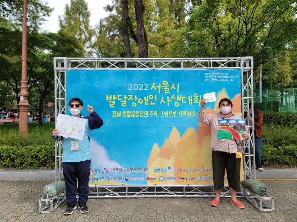 완성한 그림을 들고 사진을 찍는 모습