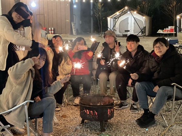 따뜻한 화로 주위에 모여 불꽃놀이를 하는 직원들