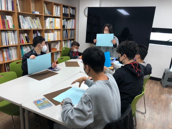 파란 도화지를 이용하여 수업을 듣는 아이들의 모습.