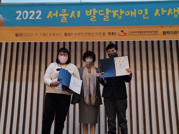 상을 받고 다른 사람들과 함께 사진을 찍는 모습