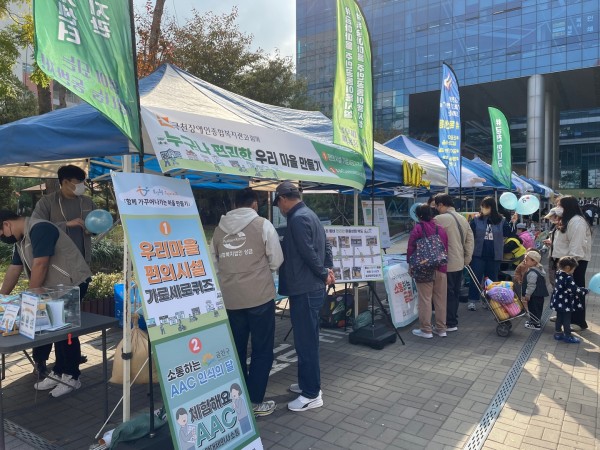 복지관 부스에서 설명 듣는 사람들의 모습