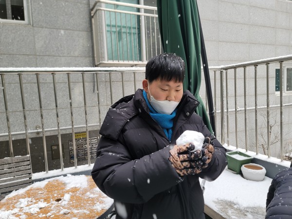 눈을 맞으며 눈사람을 만드는 모습