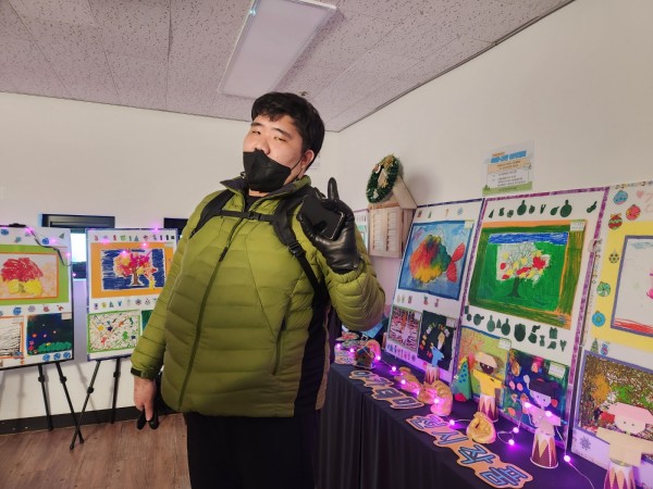 전시품 앞에서 브이 포즈를 취하는 이용자의 모습