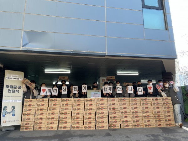 직원들과 함께 비빔면 200박스 뒤에서 따띠삼겹이 함께합니다 써있는 종이들고 사진촬영