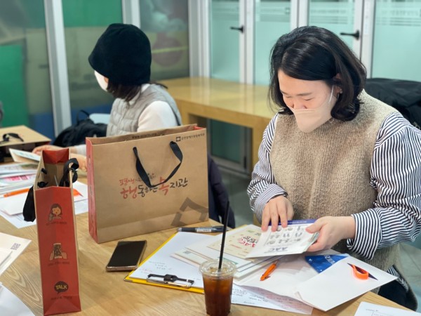 복지관의 리플렛과 소개지를 살펴보는 모습