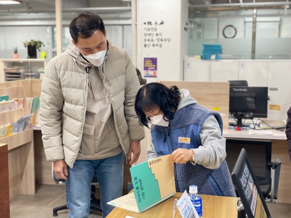 동주민센터에 있는 aac 그림글자판을 살펴보는 모습