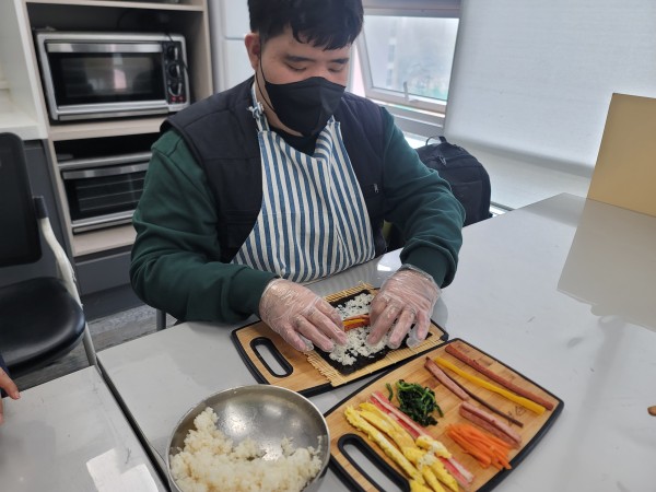 김밥 속재료를 넣고 김밥을 싸는 모습