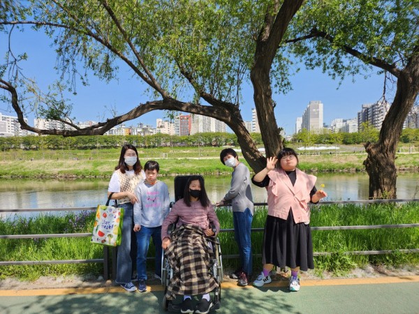 안양천 산책로 옆 초록색 잎사귀가 무성한 나무그늘아래서 찍은 단체사진