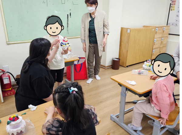 완성한 미술 작품을 친구들 앞에서 발표하는 아동의 모습