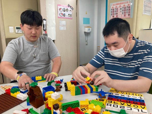 블록으로 집과 자동차를 만들고 있는 이용자