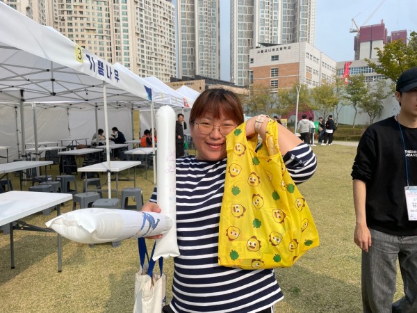 장바구니 들고 웃는 체험 여성 참가자 사진
