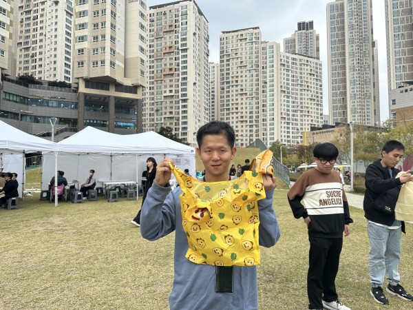 장바구니 들고 웃는 체험 남성 참가자 사진