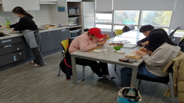 친구들과 함께 만두속을 넣어 만두를 빚는 모습