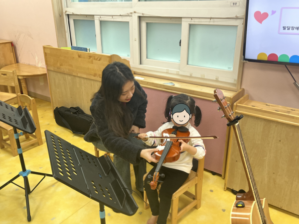바이올린 악기체험을 하고 있는 모습
