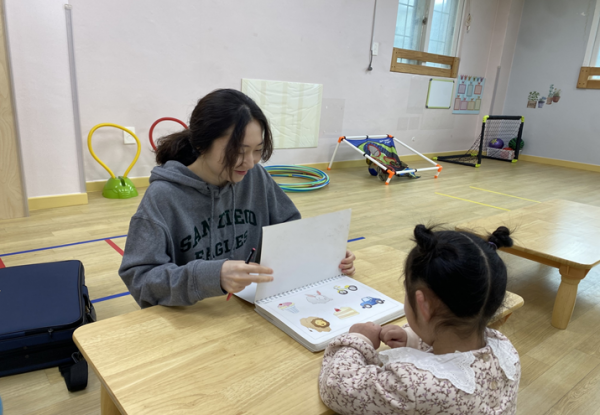 언어치료사와 아동이 마주보고 이야기 나누고 있는 모습