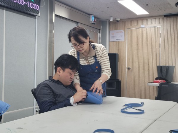 강사 선생님과 바느질을 하고 있는 이용자의 모습