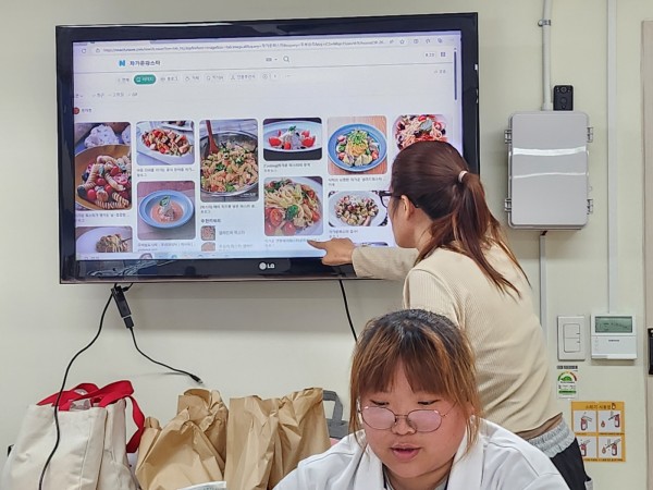 완성된 요리 사진을 보고 만들고 싶은 요리를 정하는 모습
