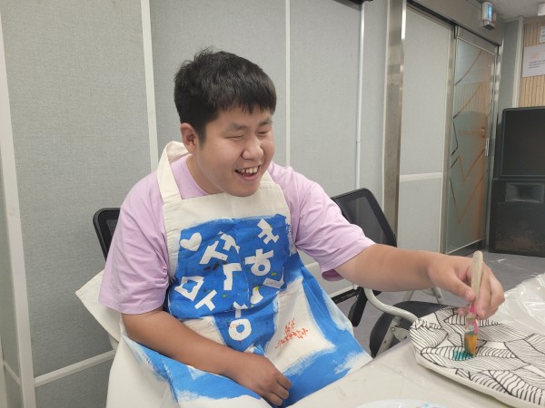 완성된 앞치마를 착용하고 웃고 있는 모습