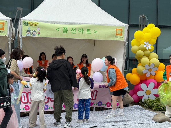 풍선아트 부스 앞에 풍선을 받기 위해 줄 선 모습