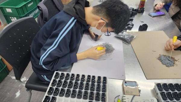 뭉쳐있는 쇠구슬을 송곳으로 분리하는 모습