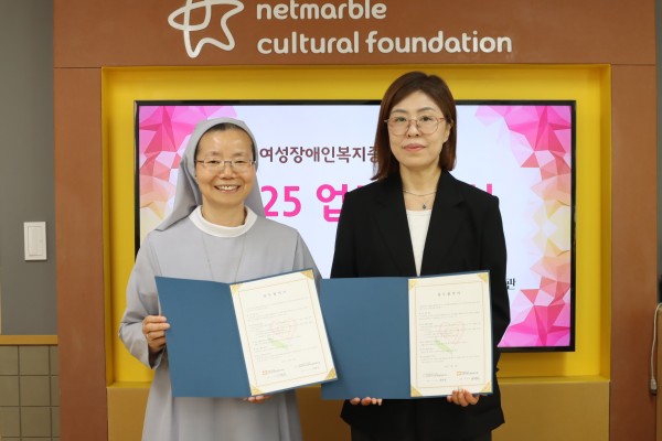 (좌) 성프란치스꼬장애인종합복지관 이선영 관장 / (우) 금천장애인종합복지관 박은정 관장 업무협약서를 들고 앞을 보고 있는 모습