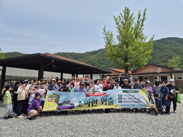 금천구 장애인 31가정이 현수막을 들고 양평원조외갓집체험마을에서 단체사진을 찍고있는 모습