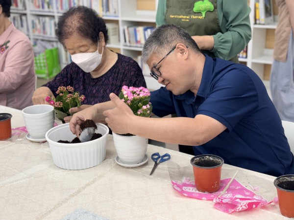 화분에 흙을 넣어 꽃 화분을 만드는 모습