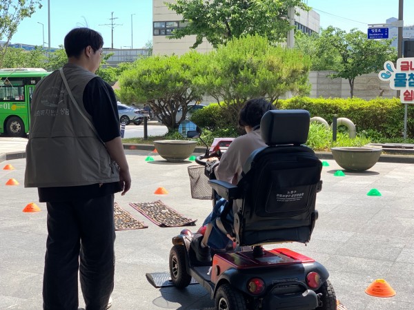 전동보장구를 직접 만져보고 코스따라 담당자와 함께 주행하는 모습