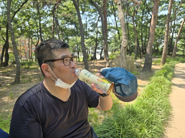 그늘에서 음료를 마시는 모습