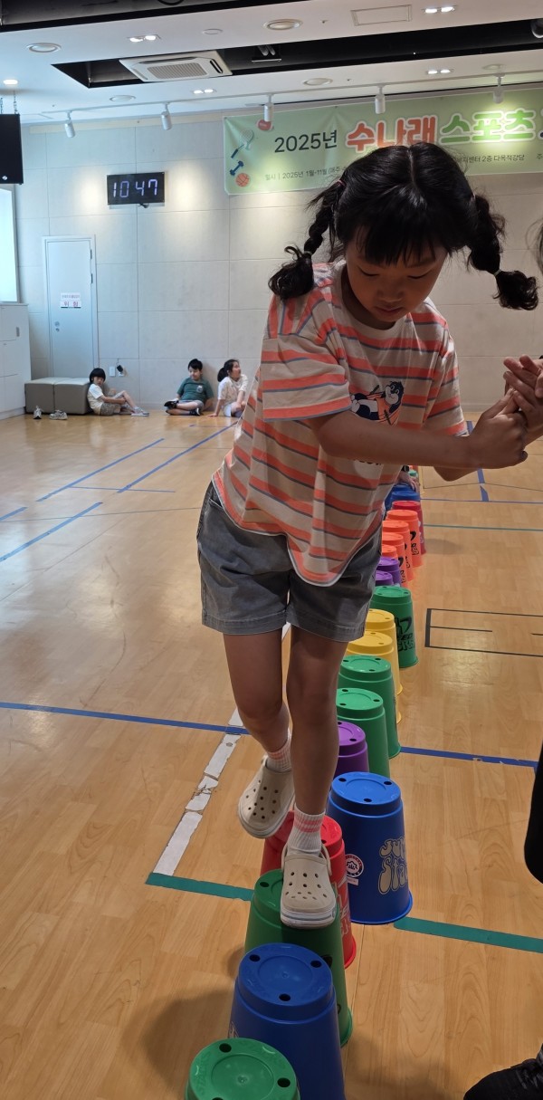 큰 스태킹 컵 위를 걷기 위해 손을 꽉 잡은 모습