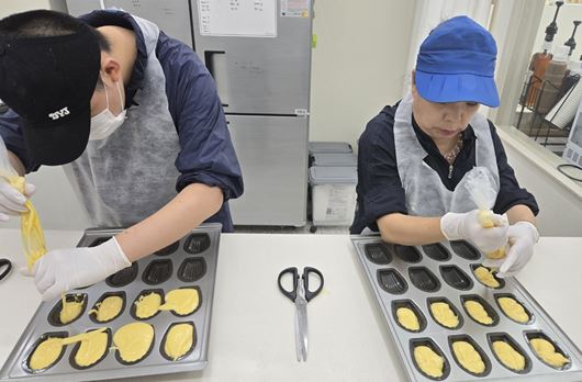 만들어진 빵 반죽을 빵 틀에다가 이쁘게 담고 있는 모습