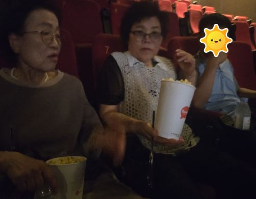 자조모임 참여자와 아들이 함께 영화관에 앉아서 이야기하는 모습