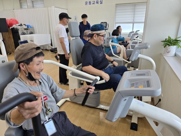 운동기구 사용 방법을 옆사람에게 설명해주는 모습