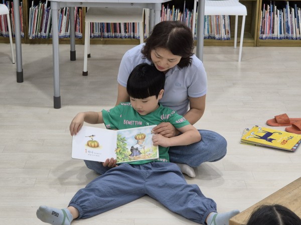 앞에서 친구들에게 책을 읽어주는 모습