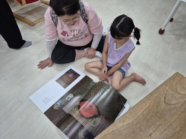 봉사자와 함께 책을읽고 있는 모습